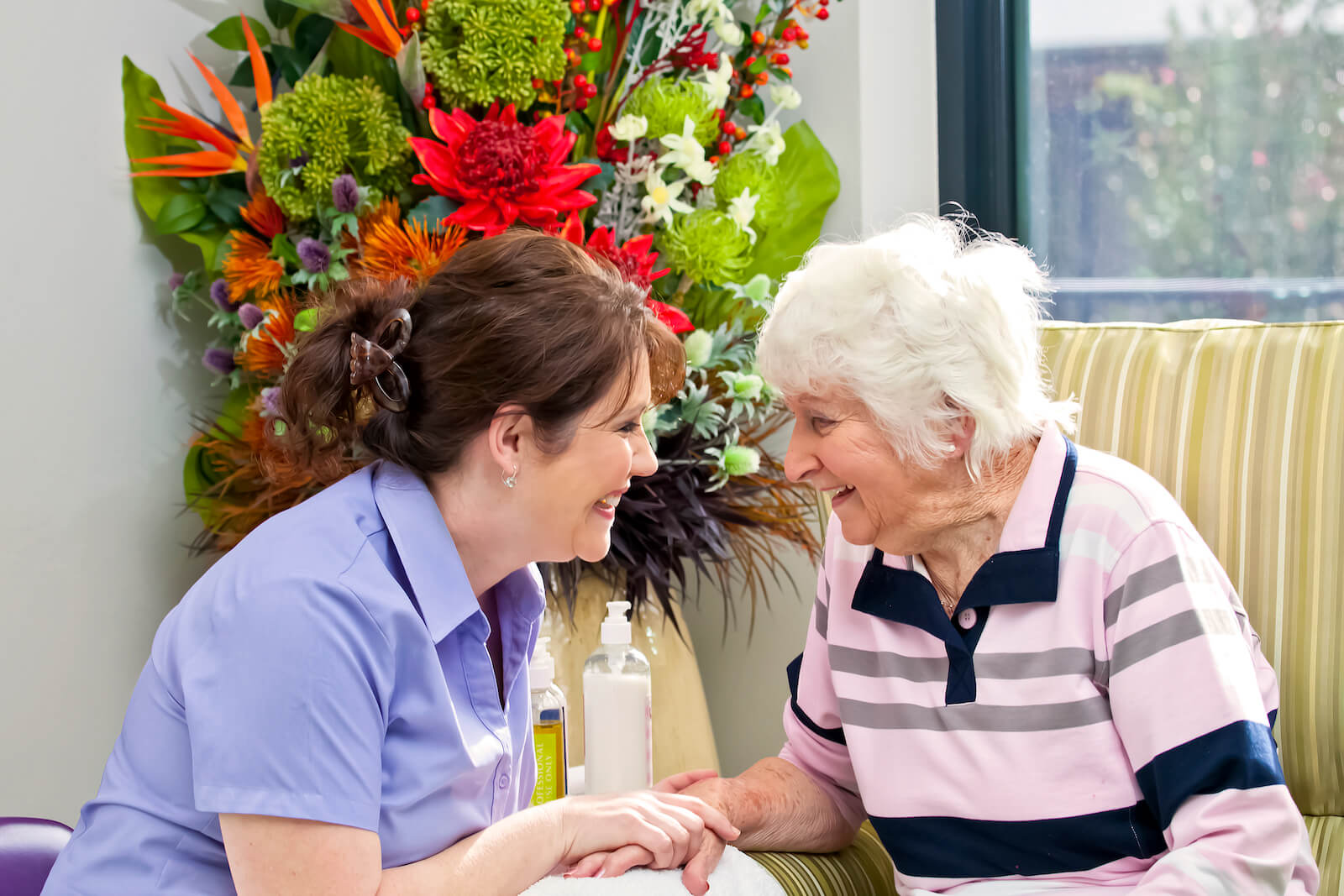 An old woman and a nurse smiling